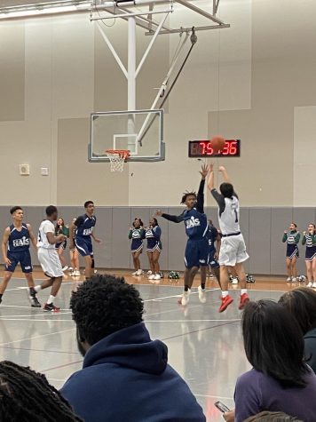 Rhino Noah Needle, player #1 defended by Johnson, player #7 on HAIS while shooting a three-pointer.