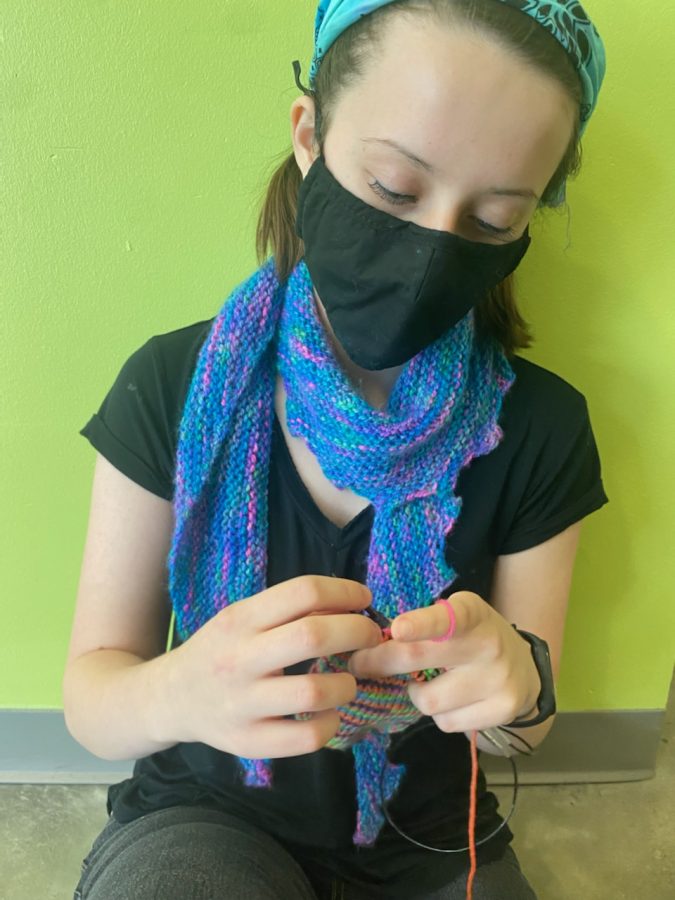 Senior Brooke Ferrell, founder of CVHS yarn club, crochets while wearing her handmade scarf.