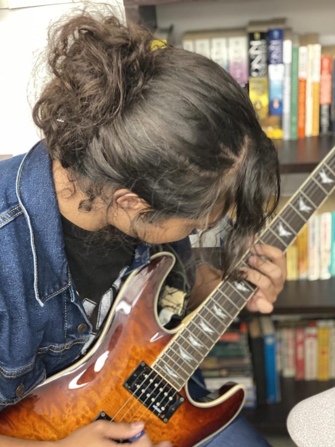 Diego Mendez plays his guitar in music theory class during the weekly jam sessions. 