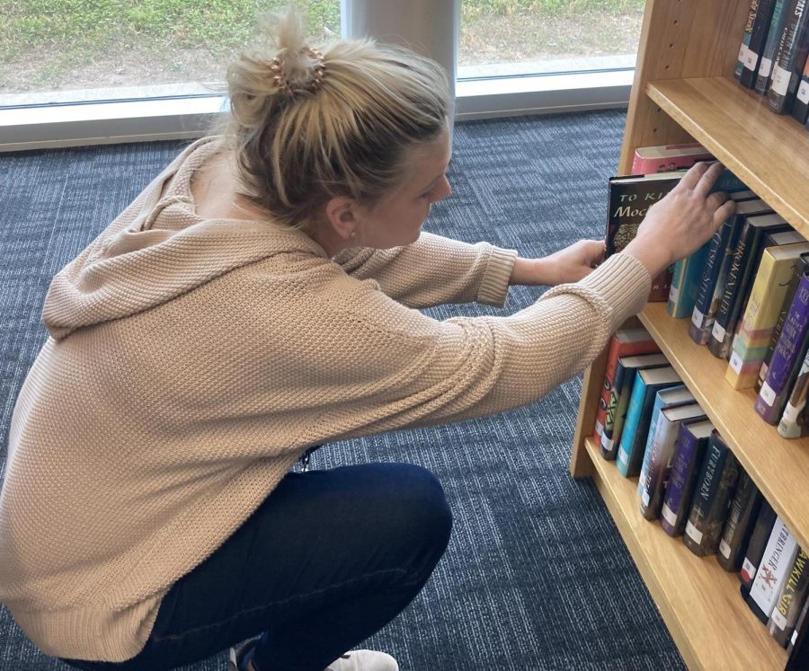 Ms. Schulze works to arrange books on the shelves. 