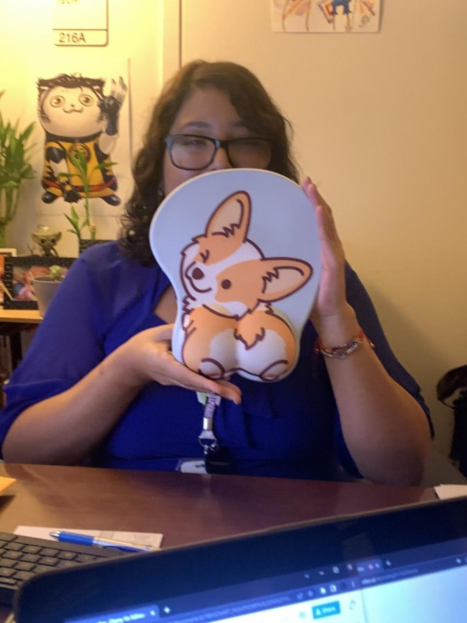 Ms. Sanchez holds up her corgi mousepad, one of many corgi-themed things in her office.
