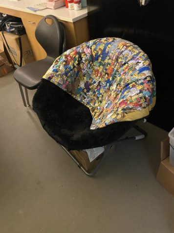 a small black foldable chair with Simpson's themed throw blanket draped over it.