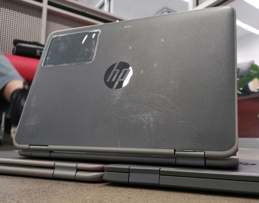 A school laptop shows its scratches and scuffs, its scars of war .