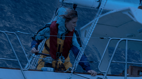 Teagan Croft as Jessica Watson leaning on railing for support as she braves a storm. [Netflix]