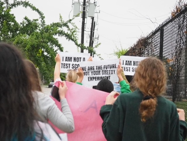 Multiple Carnegie students attend the walkout in protest of the TEA takeover while holding up signs (Ava Craft)