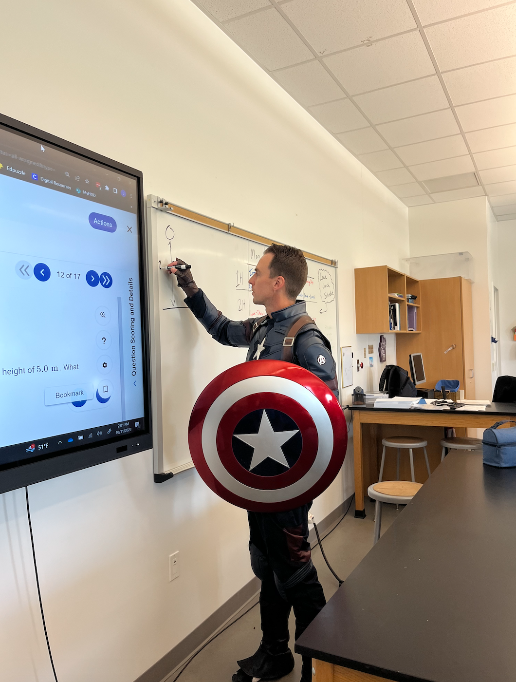 Jonathan Lowe, wearing a Captain America costume while drawing a free-body diagram.