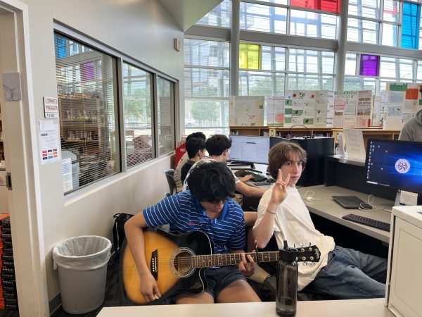 Isaac Antao playing the guitar in the school library for his friends. 