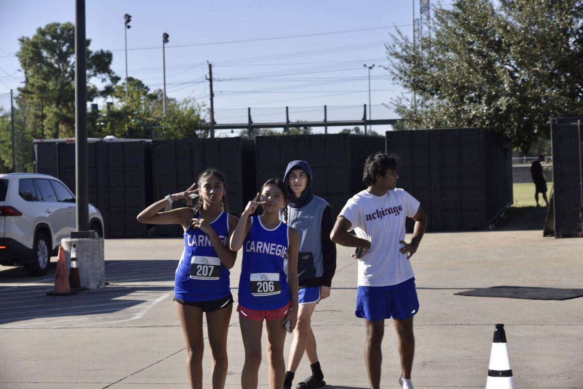  Both Girls and boys athletes at a meet cheering together.

Pictured left to right: Nina Pinglay, Lillie Pham, Alejandro Olmos, Abhiram Jyosyla,