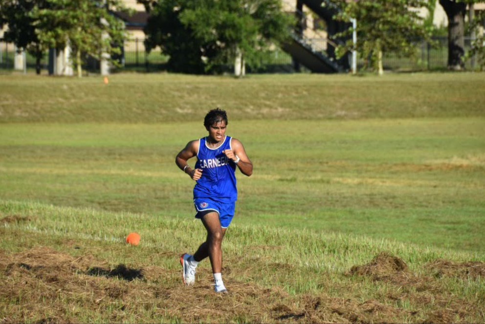 Abhiram Jyosyula running through a cross country course, treading along.