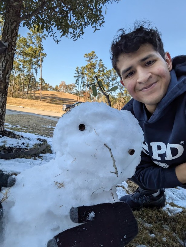 Ismael Guel poses with a snowman during  a Houston snow day after taking a break from a long day of writing. 